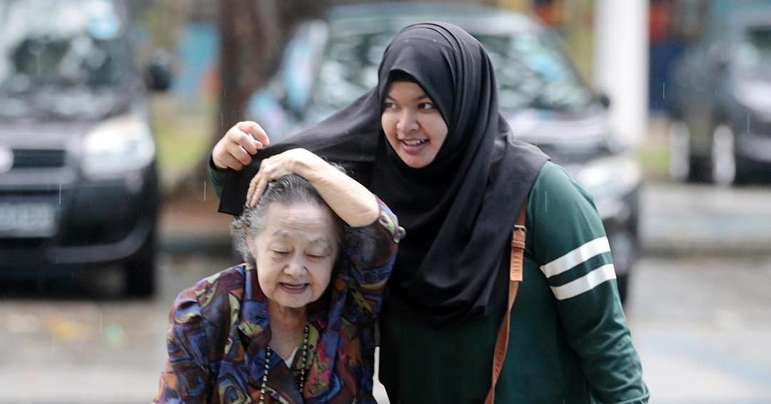Heboh, Wanita Ini Melindungi Seorang Nenek dengan Jilbabnya Saat Hujan!
