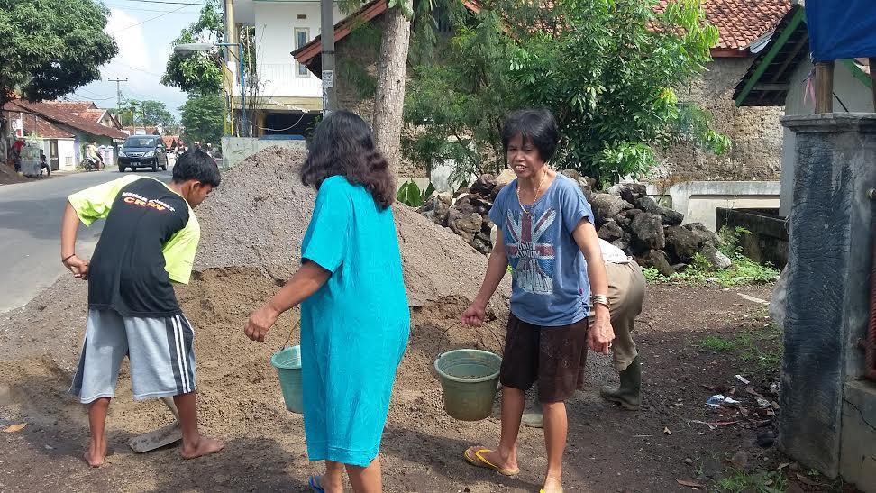 Sambil Gendong Anak, Emak-emak Ikut Bangun Jalan Desa