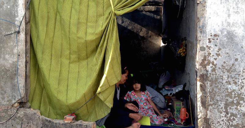 Berteduh. Tini dan cucunya berteduh dari teriknya matahari yang menerjang Kampung Taman Kota. Foto oleh Christian Simbolon/Rappler