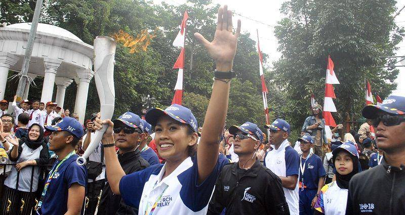 (Artis dan pelari Melanie Putria (tengah) membawa api obor Asian Games 2018) ANTARA FOTO/Arif Firmansyah