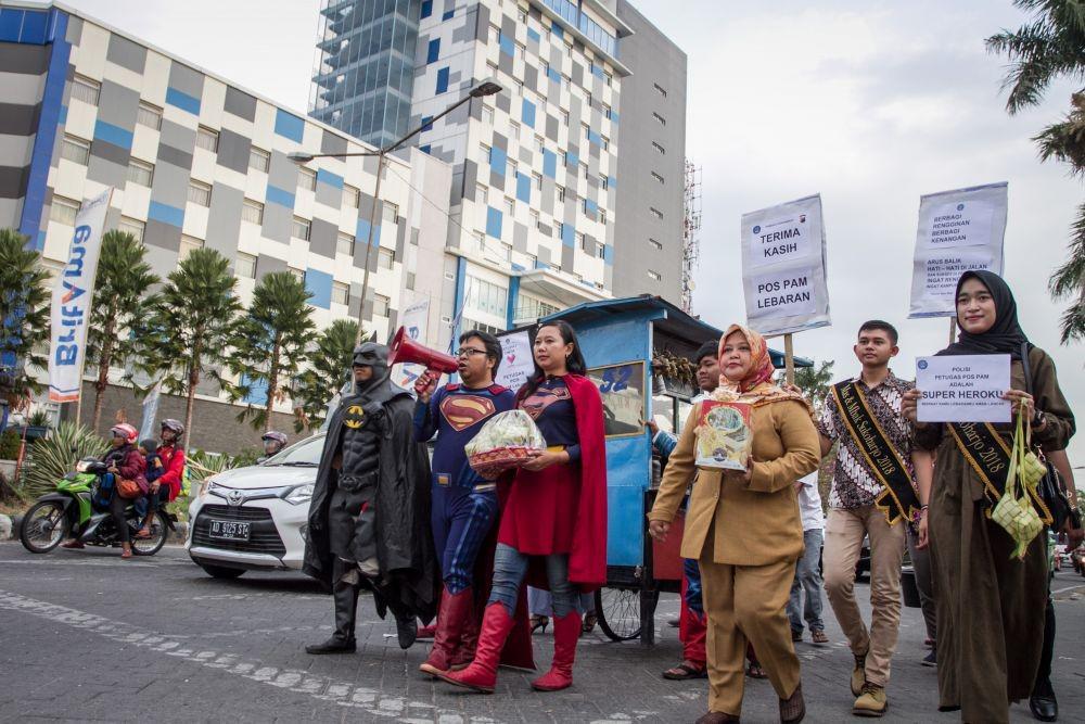 Aksi Superman, Batman, dan Spiderman Bagi-bagi Ketupat untuk Polisi