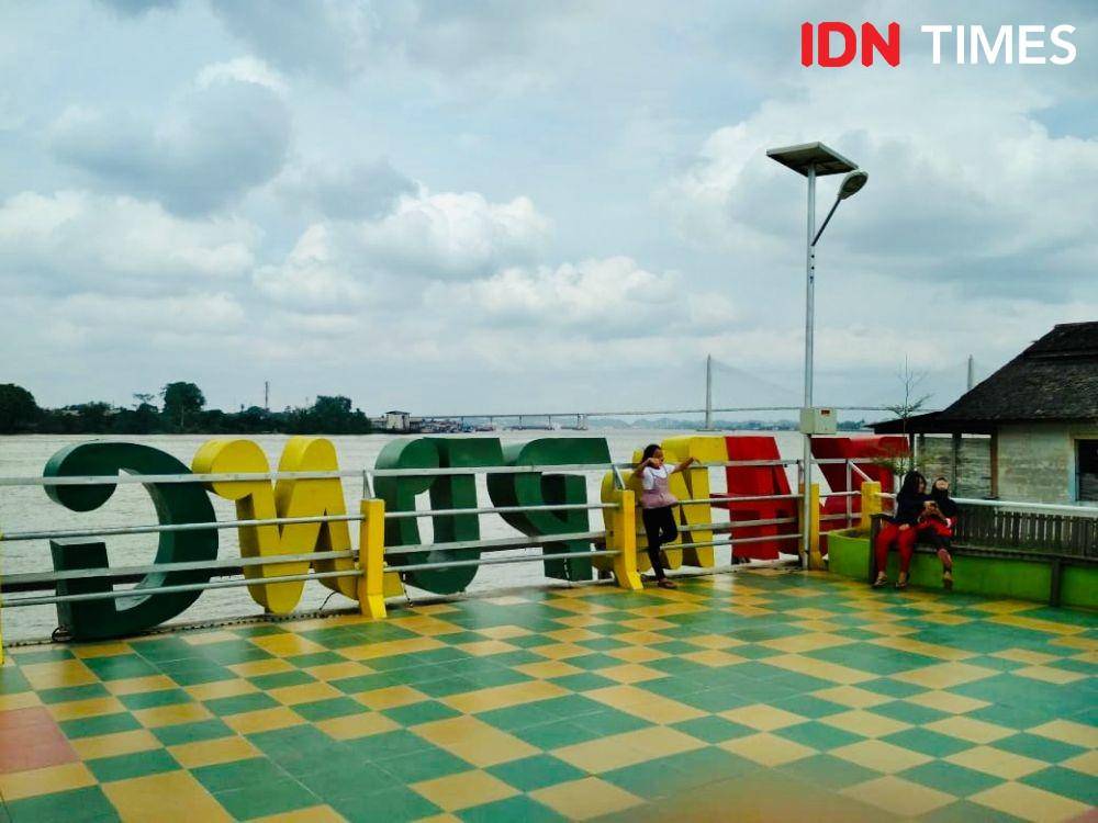Warga sekitar tampak asyik menikmati pemadangan Sungai Mahakam dari Kampung Ketupat di Samarinda Seberang (IDN Times/Yuda Almerio)