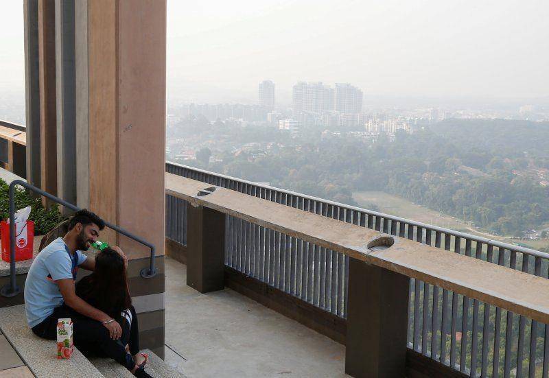 Pasangan duduk di dek observasi saat langit diselimuti kabut di Singapura pada 12 September 2019. ANTARA FOTO/REUTERS/Feline Lim