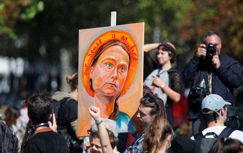 Seorang pria membawa poster mirip aktivis iklim Swedia Greta Thunberg saat warga berpartisipasi dalam aksi protes perubahan iklim "Fridays for Future" di Paris, Prancis pada 20 September 2019. ANTARA FOTO/REUTERS/Charles Platiau