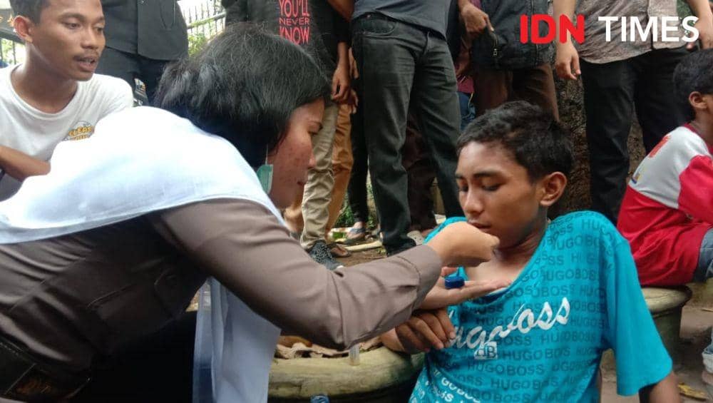 Polisi Berhijab Putih Suapi Makan Pelajar yang Ikut Demo di DPRD Sumut