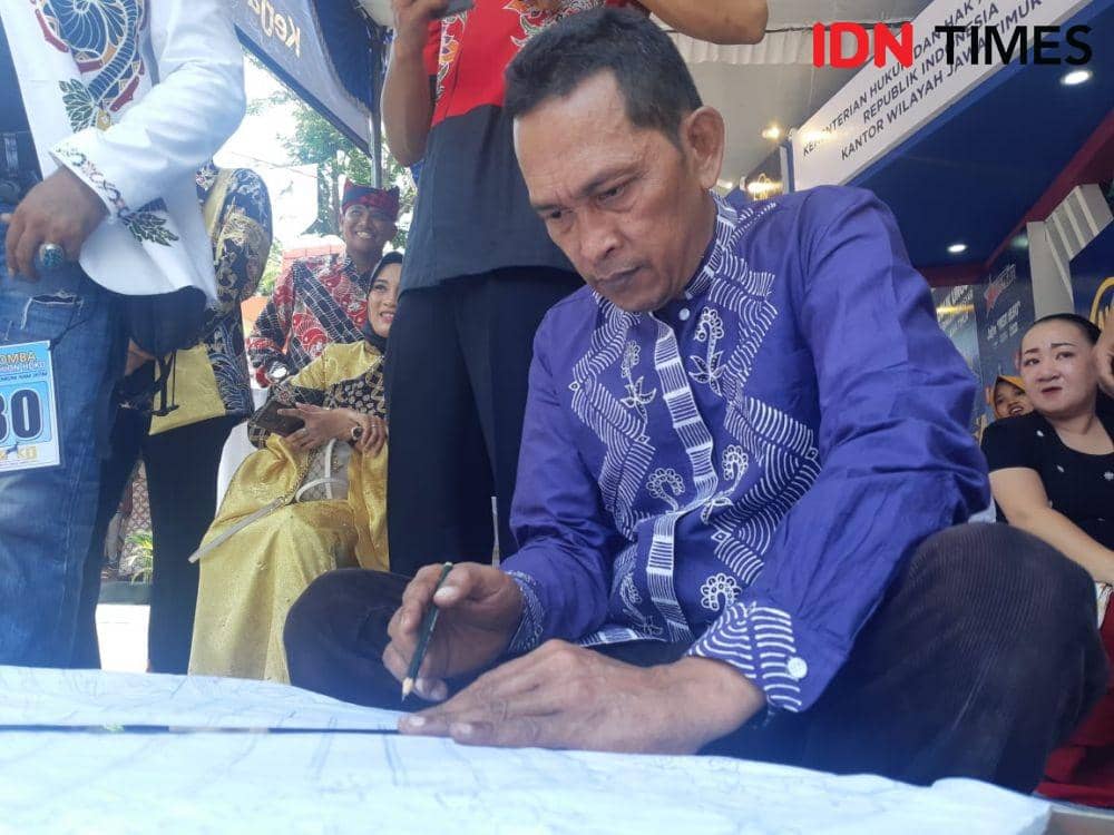 Desainer sekaligus Warga Binaan Lapas Klas 2A Banyuwangi, Suliyono (51) saat menggambar motif Batik Jeruji di Kemenkumham Kanwil Jatim, Selasa (29/10). IDN Times/Ardiansyah Fajar.