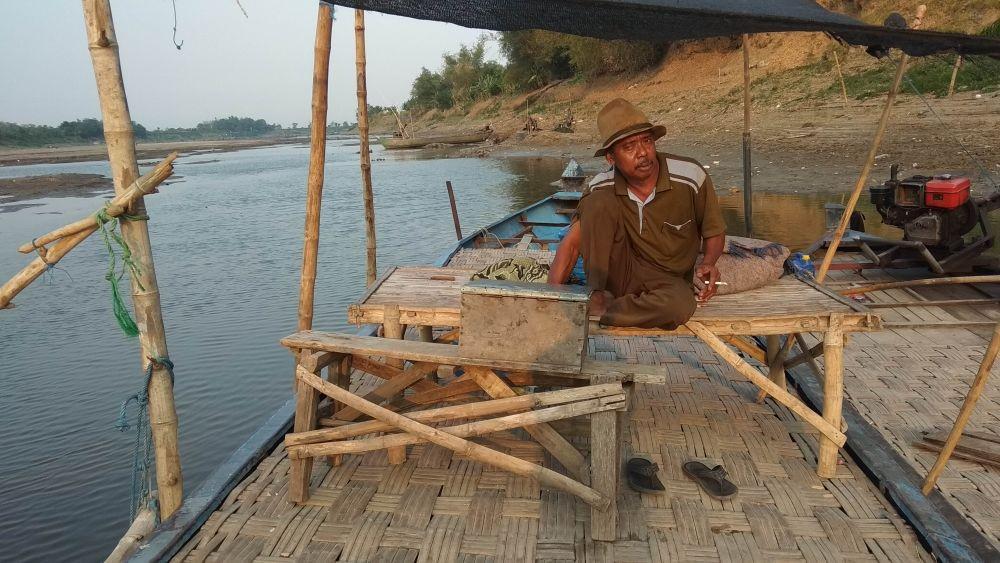 Tari (60) tetap setia menunggu warga yang menyeberang meski penghasilan berkurang. IDN Times/Imron