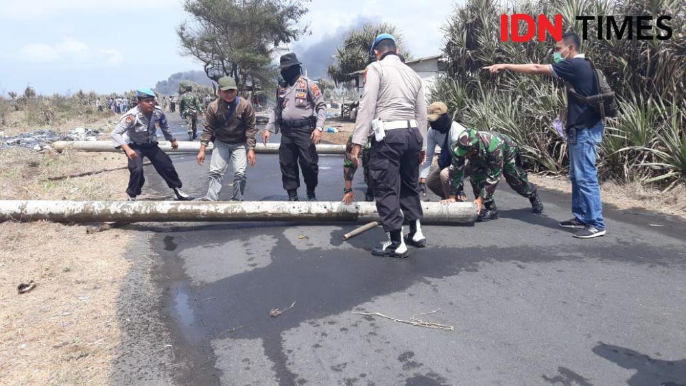 Warga blokir jalan dengan batang pohon kayu. IDN Times/Daruwaskita
