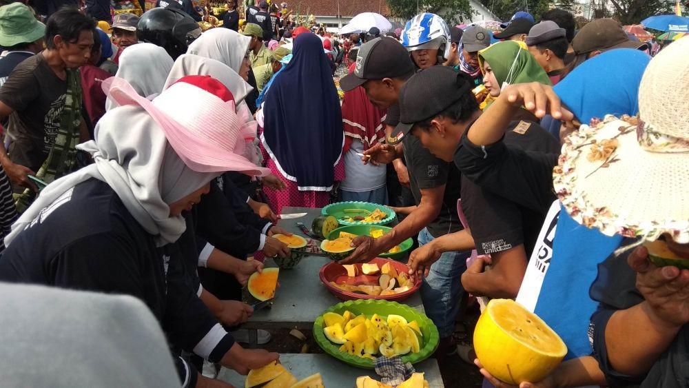 Warga mencicipi buah yang dibagikan oleh panitia. IDN Times/Imron