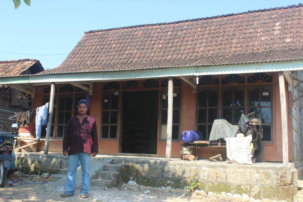 Sunarto pria asal Tuban yang dikabarkan meninggal dunia lalu balik ke rumah, berdiri di depan pintu masuk rumahnya. IDN Times/Imron
