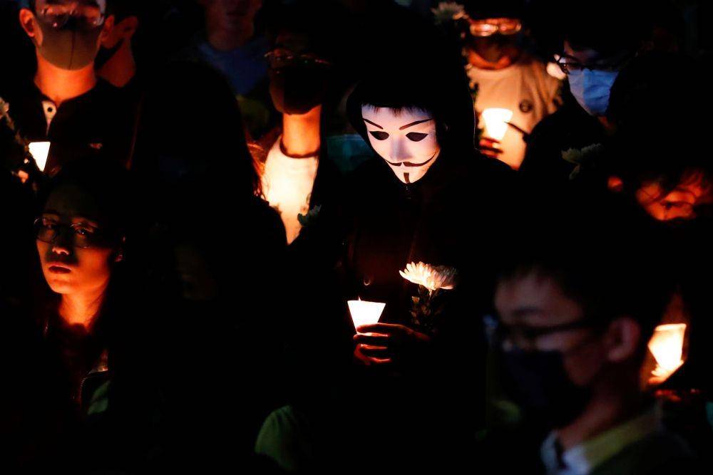 Seorang pria memakai topeng Guy Fawkes saat upacara pemberian penghormatan Cow Tsz-lok, 22 tahun, mahasiswa yang jatuh saat protes pada akhir pekan dan meninggal dunia pada Jumat pagi, di Hong Kong University of Science and Technology, Hong Kong, pada 8 November 2019. ANTARA FOTO/REUTERS/Tyrone Siu
