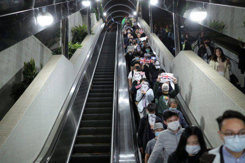 Pengunjuk rasa anti-pemerintah memakai masker mirip Simon CHneg, seorang mantan karyawan Konsulat Inggris, menaiki eskalator di sebuah pusat perbelanjaan saat reli di Hong Kong, pada 29 November 2019.  ANTARA FOTO?REUTERS/Marko Djuric
