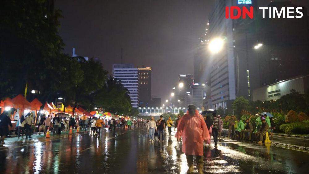Hujan-hujanan, Masyarakat Antusias Rayakan Tahun Baru di Bundaran HI