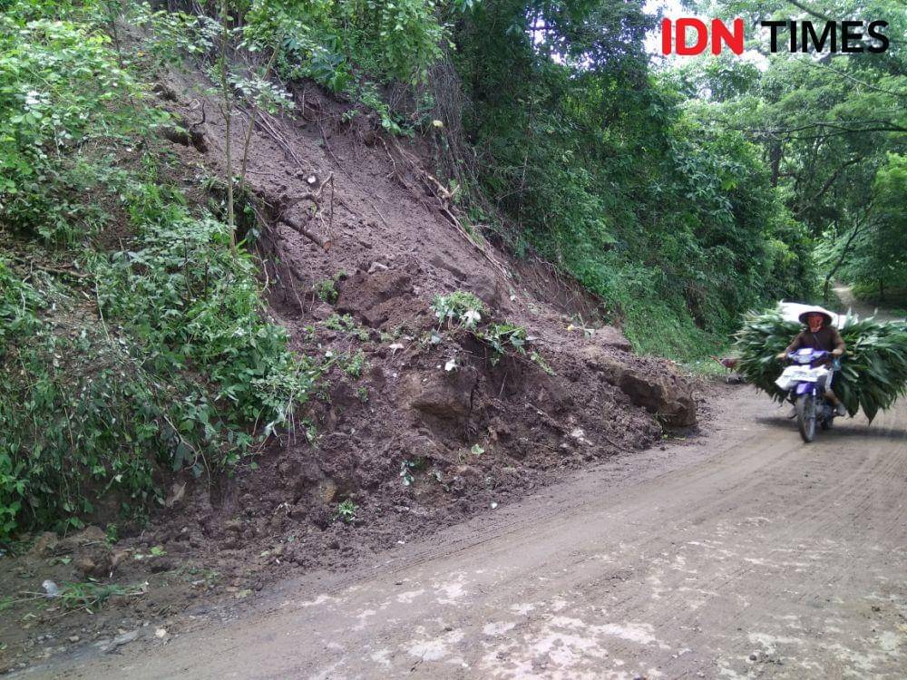 Seorang warga sedang melintas di titik jalan Desa Sumberbendo, Saradan, Kabupaten Madiun yang telah bersih dari material Longsoran. IDN Times/Nofika Dian Nugroho