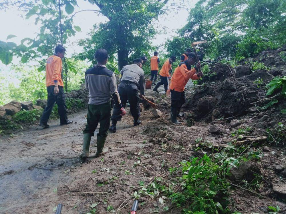 Petugas kepolisian dan BPBD Kabupaten Madiun melakukan pembersihan jalan dari material longsor yang menutupi di Desa Sumberbendo, Kecamatan Saradan, Kabupaten Madiun. Dok.IDN Times/Istimewa