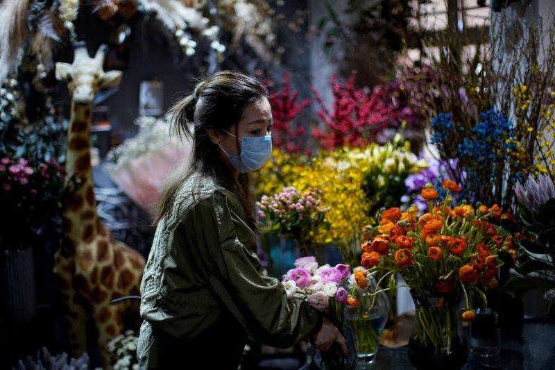 Penjual bunga Wang Haiyan, 41 tahun, bekerja di antara bunga-bunga di dalam toko miliknya saat negeri tersebut sedang terjadi penularan virus corona baru di Shanghai, Tiongkok, pada 5 Februari. ANTARA FOTO/REUTERS/Aly Song