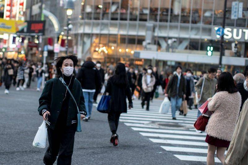 Seorang perempuan memakai masker pelindung berlari menyebrang jalan di Shibuya di Tokyo, Jepang, pada 17 Februari 2020. (ANTARA FOTO/REUTERS/Athit Perawongmetha)