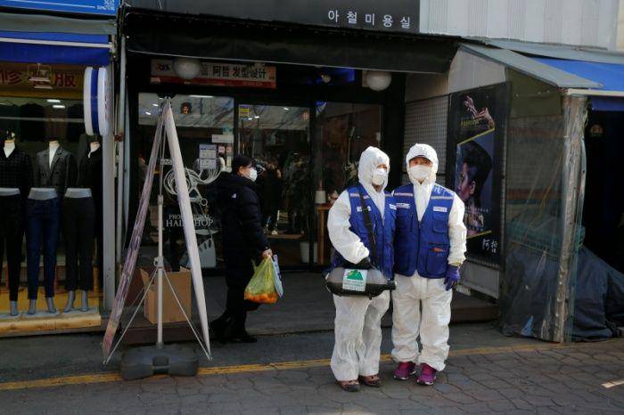 Pegawai dari perusahaan layanan desinfektan menunggu untuk mensanitasi pasar tradisional di Seoul, Korea Selatan,pada 5 Februari 2020. (ANTARA FOTO/REUTERS/Heo Ran)