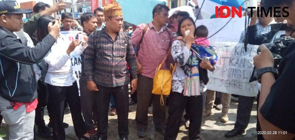 Sembari menggendong anak, seorang guru honor minta SK dan gaji diberikan Disdik (IDN Times/Patiar Manurung)