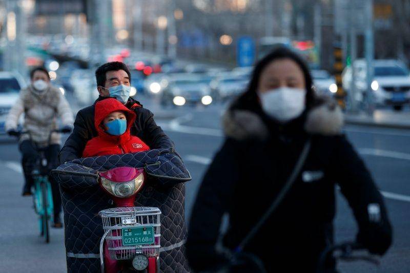 Warga memakai masker pelindung saat mereka mengendarai sepeda motor pada malam sibuk, saat negeri tersebut sedang terjadi penularan COVID-19, di Beijing, Tiongkok, pada 3 Maret 2020. ANTARA FOTO/REUTERS/Thomas Peter