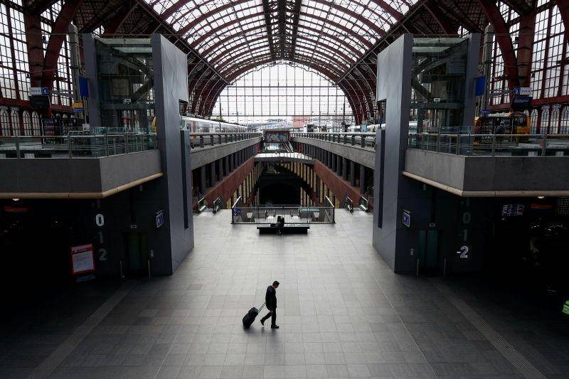 Seorang pria berjalan sambil menarik koper di stasiun kereta yang sepi, setelah pemerintah memberlakukan 'lockdown' untuk mencegah penyebaran COVID-19, di Antwerp, Belgia, pada 18 Maret 2020. ANTARA FOTO/REUTERS/Francois Lenoir