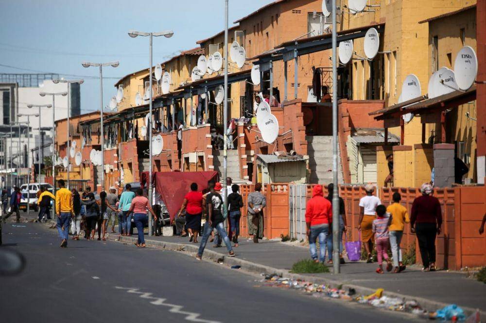 Warga berjalan di jalan di kota Langan saat "lockdown" selama 21 hari yang bertujuan membatasi penyebaran penyakit virus corona (COVID-19) mulai diberlakukan di Cape Town, Afrika Selatan, Jumat (27/3). ANTARA FOTO/REUTERS/Sumaya Hisham