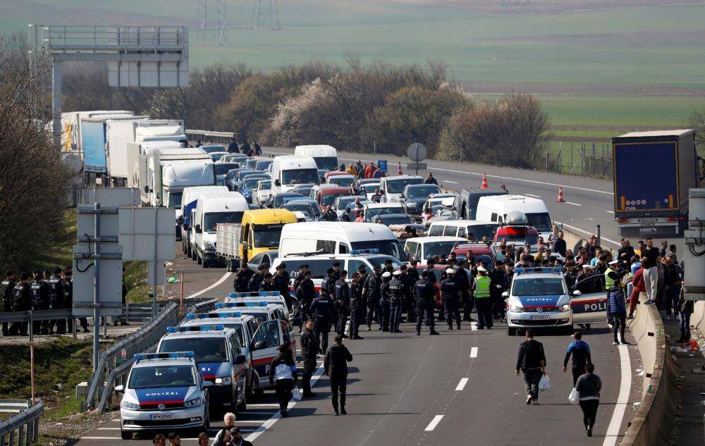 Warga dan polisi berkumpul saat perbatasan Hungaria-Austria ditutup di tengah meluasnya penyebaran virus corona baru, dekat Nickelsdorf, Austria, pada 18 Maret 2020. ANTARA FOTO/REUTERS/Leonhard Foeger