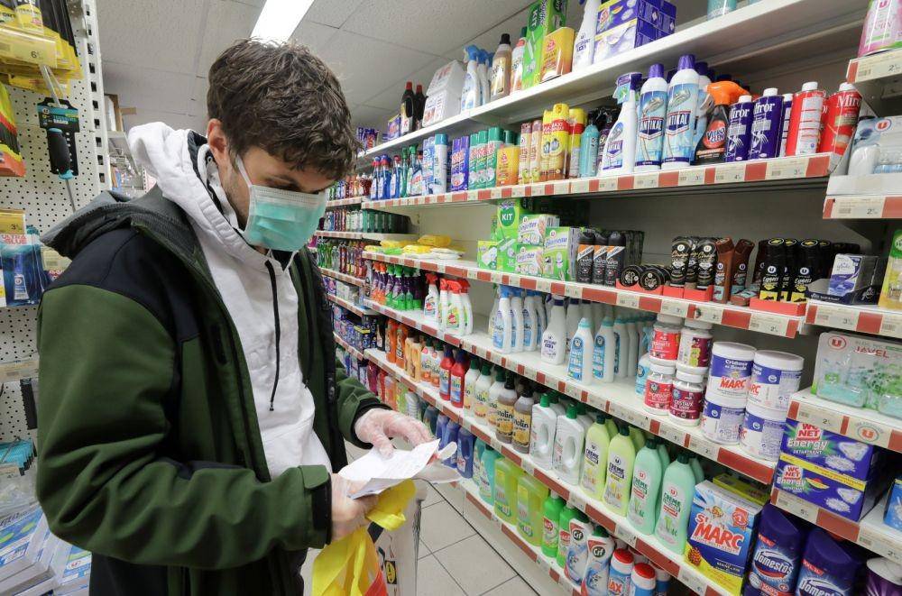 Seorang pengunjung supermarket di Paris, Prancis, memakai masker ketika membaca daftar belanjaan, pada 26 Maret 2020. ANTARA FOTO/REUTERS/Eric Gaillard