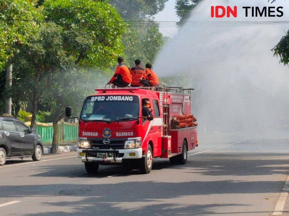 Mobil BPBD Jombang semprotkan cairan Disinfektan di Jalan Wahid Hasyim. IDN Times/zainul arifin