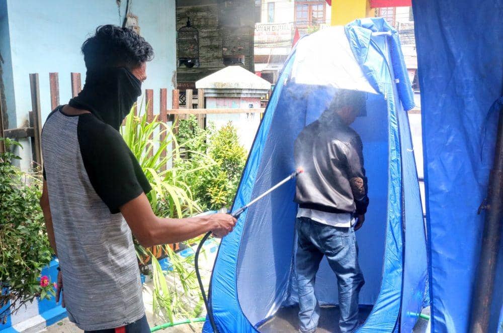 Seorang warga disemprot sebelum masuk ke wilayah Ketawanggede, Kota Malang. IDN Times/ Alfi Ramadana
