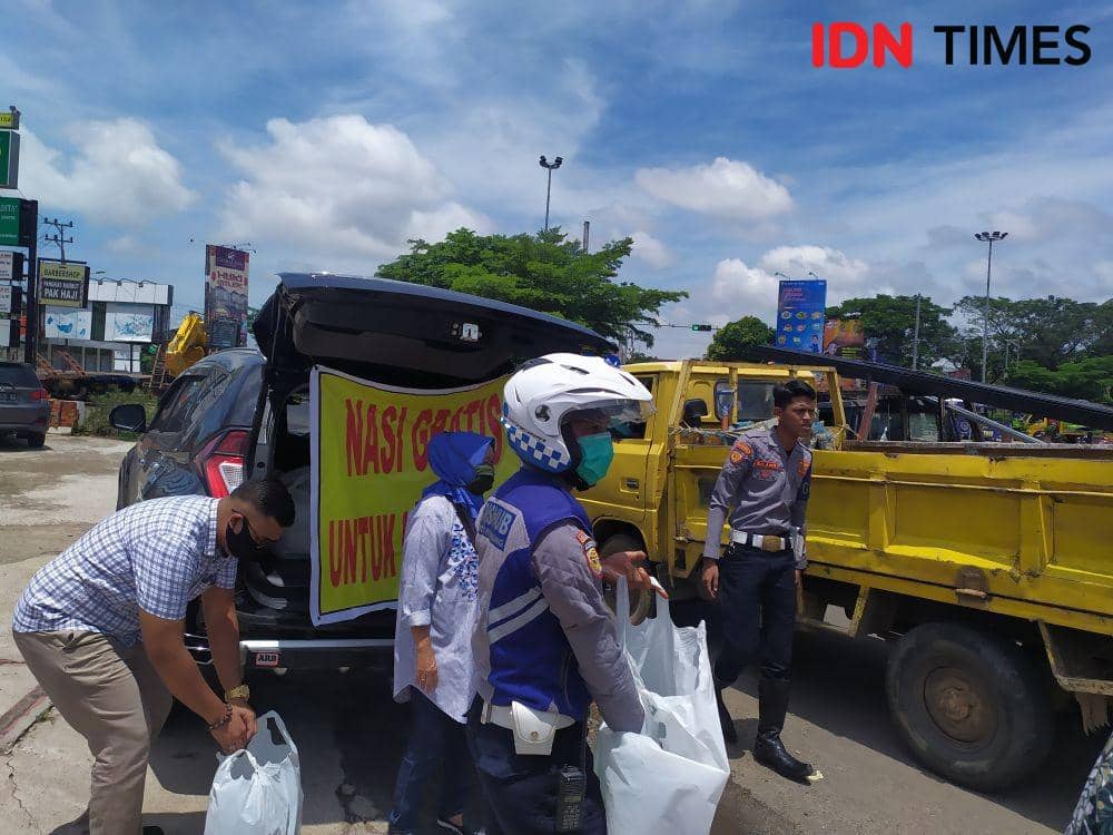 Pembagian nasi gratis pada masa Covid-19 di Palembang (IDN Times/Feny Maulia Agustin)