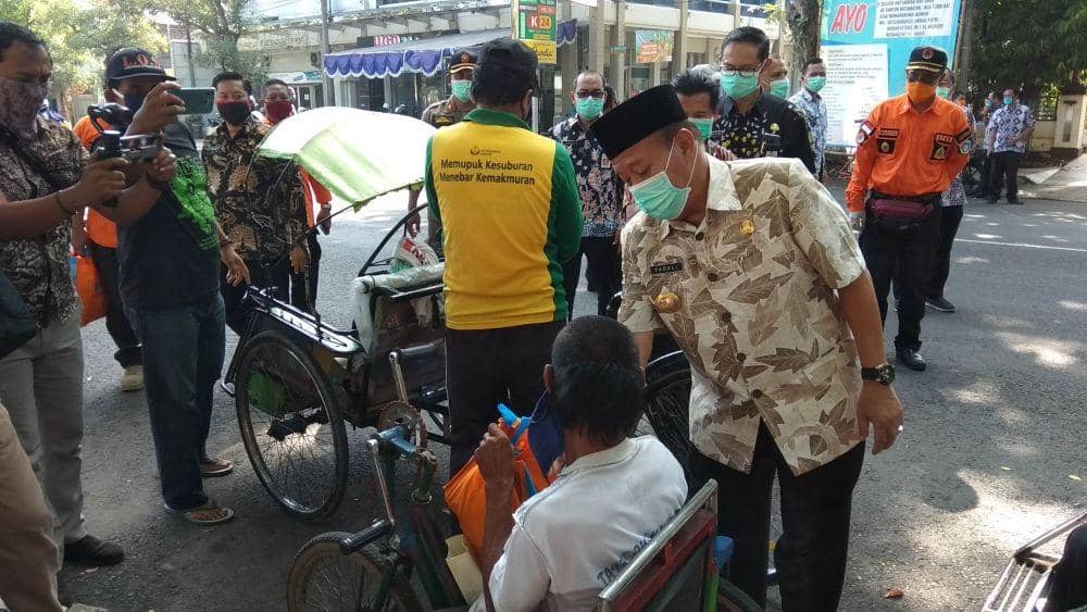 Bupati Lamongan Fadeli saat membagikan masker peda warga. (IDN Times/Imron)