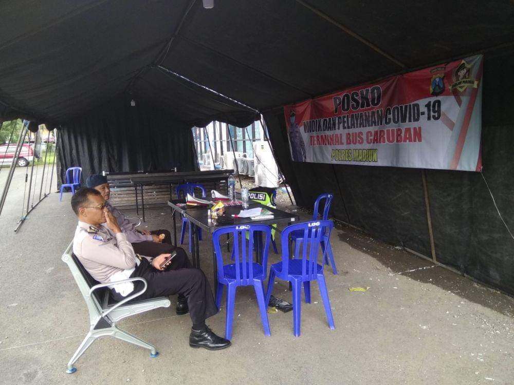 Personel kepolisian bersiaga di posko pemantauan pemudik di Terminal Bus Caruban, Kabupaten Madiun. (IDN Times/Nofika Dian Nugroho)