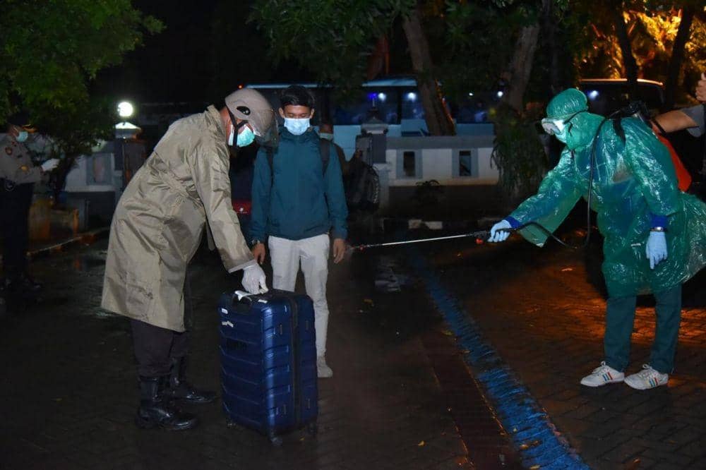 Petugas kesehatan menyemprotkan cairan desinfektan pada barang bawaan. IDN Times/Dok. Humas Polres Lamongan