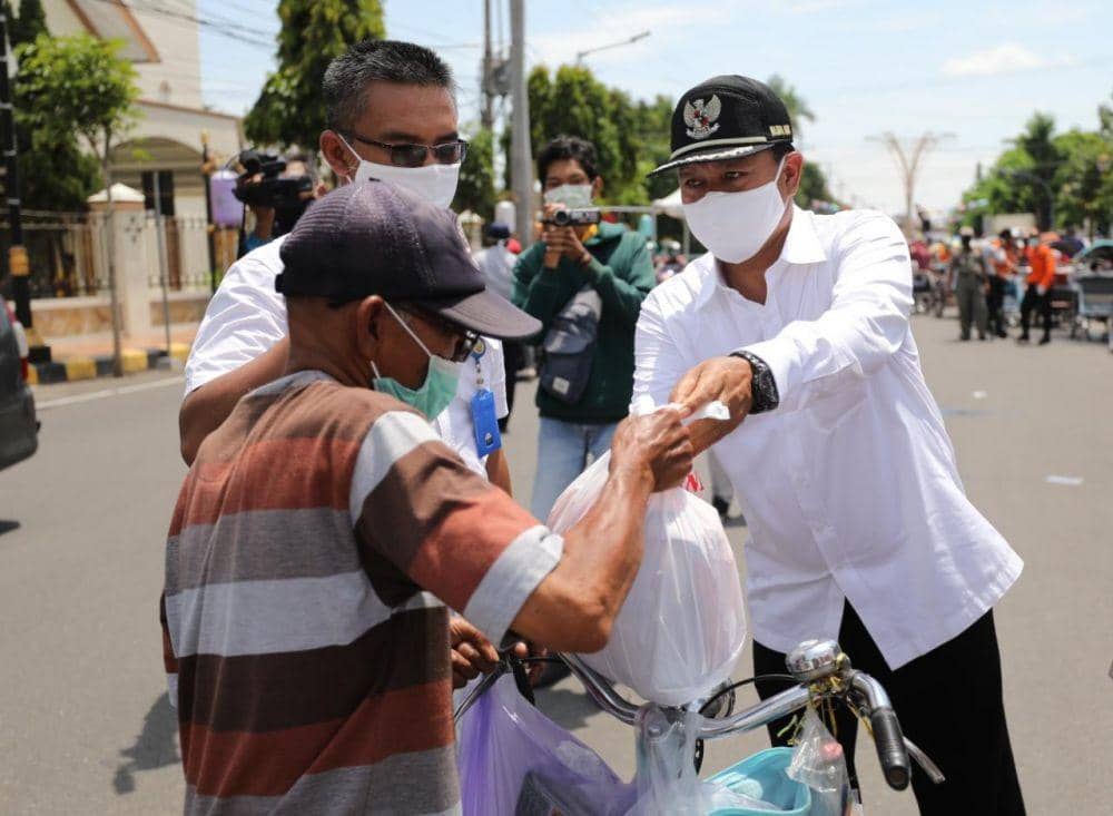 Ilustrasi. Wali Kota Madiun Maidi (kanan) menyerahkan bantuan paket sembako kepada abang becak, Rabu (8/4). Dok.IDN Times/Istimewa