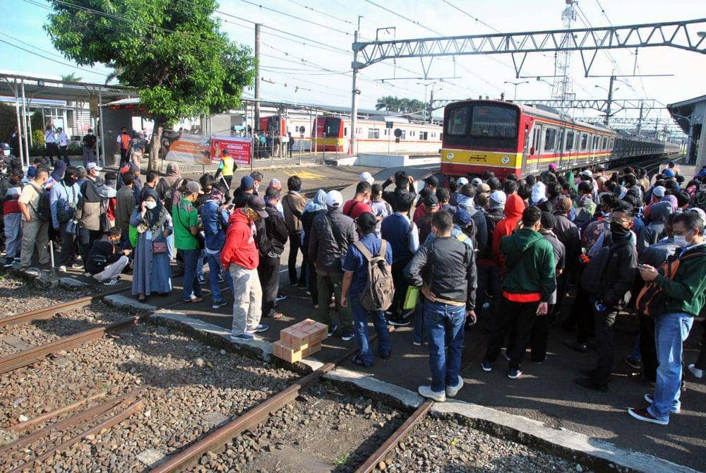 Sejumlah penumpang KRL Commuter Line mengantre menunggu kedatangan kereta di Stasiun Bogor, Jawa Barat, Senin (13/4/2020) (ANTARA FOTO/Arif Firmansyah)
