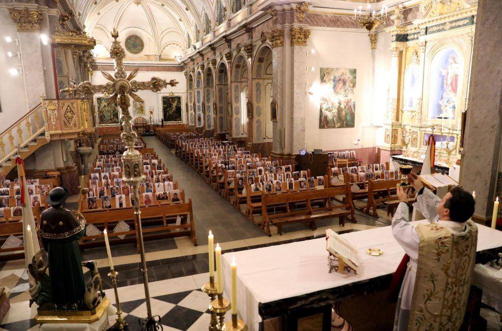 Pendeta Raul Garcia memimpin misa Pekan Suci di depan foto para jemaat gereja Nuestra Senora de La Paz saat wabah virus corona di Spanyol, pada 9 April 2020. ANTARA FOTO/REUTERS/Nacho Doce