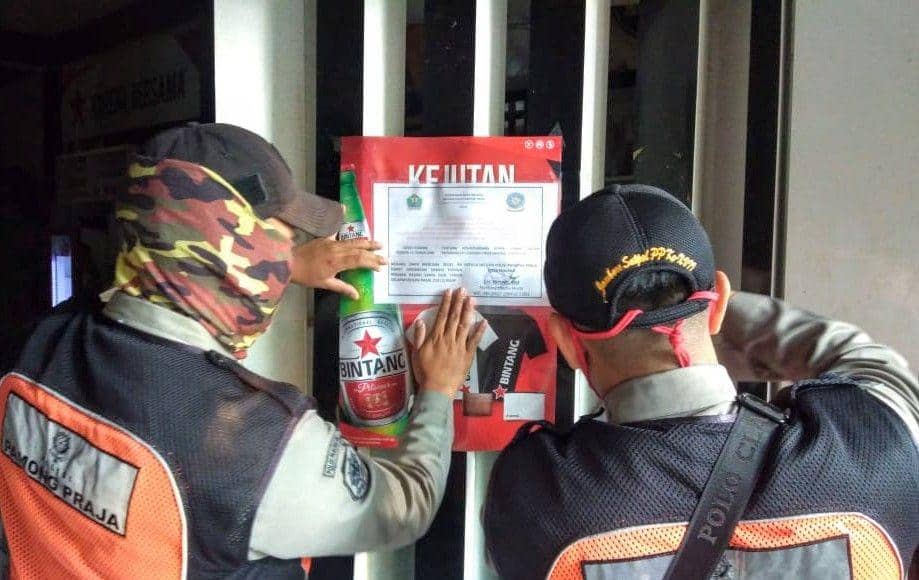 Satpol PP menempelkan pemberitahuan bahwa toko tersebut telah disegel. Dok/ Humas Pemkot Malang
