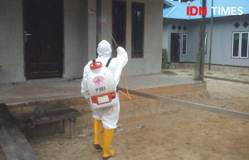 Sukarelawan PMI PPU saat melakukan penyemprotan disinfektan di pemukiman warga (IDN Times/Ervan Masbanjar)