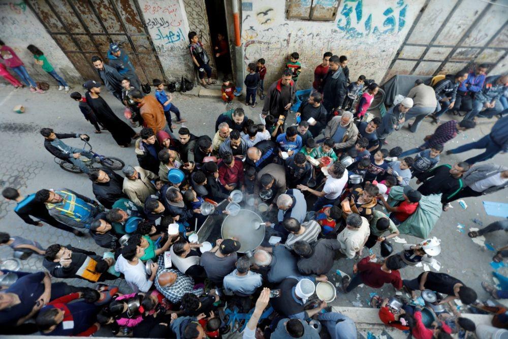 Warga Palestina berkumpul untuk mendapatkan sup diberikan gratis selama bulan puasa Ramadhan, ditengah kekhawatiran akan meluasnya penularan virus corona (COVID-19), di Kota Gaza, Minggu (26/4/2020). ANTARA FOTO/REUTERS/Suhaib Salem