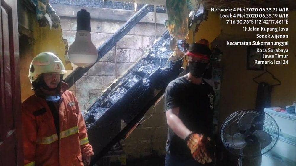 Petugas Dinas Pemadam Kebakaran Surabaya saat menunjukkan 3 Al-Quran di satu kamar yang tidak terbakar, Senin (4/5). (Dok. Dinas Pemadam Kebakaran Surabaya).
