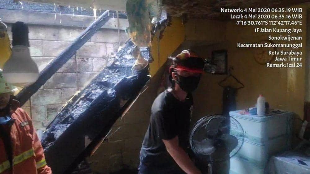 Petugas Dinas Pemadam Kebakaran Surabaya saat menunjukkan 3 Al-Quran di satu kamar yang tidak terbakar, Senin (4/5). (Dok. Dinas Pemadam Kebakaran Surabaya).