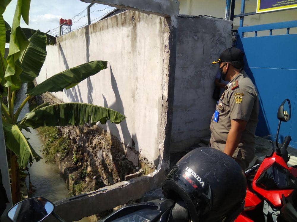 Anggota Satpol PP Kabupaten Madiun mengecek saluran irigasi sawah di depan pabrik PT Global Way Indonesia yang dinilai sebagai penyebab banjir di Desa Ngampel, Kecamatan Mejayan, Selasa (12/5). IDN Times/Nofika Dian Nugroho