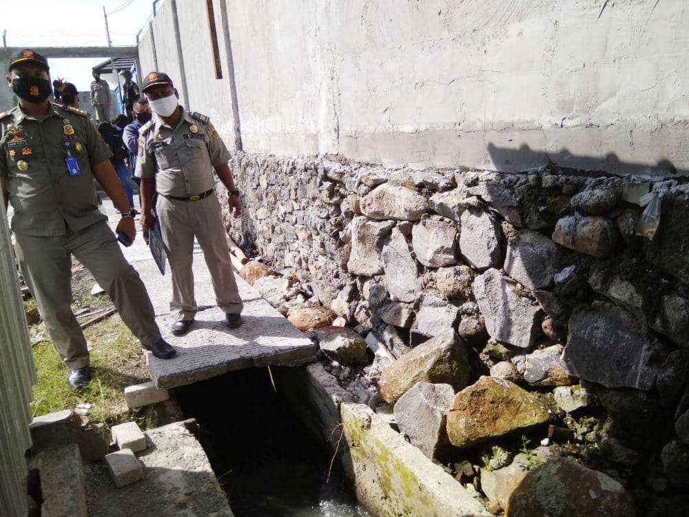 Anggota Satpol PP Kabupaten Madiun sedang mengecek saluran air yang dinilai sebagai penyebab banjir di kawasan pabrik PT Global Way Indonesia, Selasa (5/2). IDN Times/Nofika Dian Nugroho