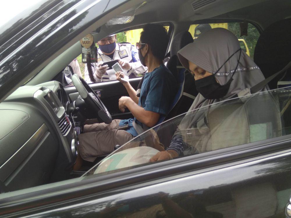Petugas Dinas Perhubungan Kabupaten Madiun sedang memeriksa kelengkapan kendaraan bermotor yang melintas di depan pos check point Nampu, Saradan, Kabupaten Madiun. IDN Times/Nofika Dian Nugroho