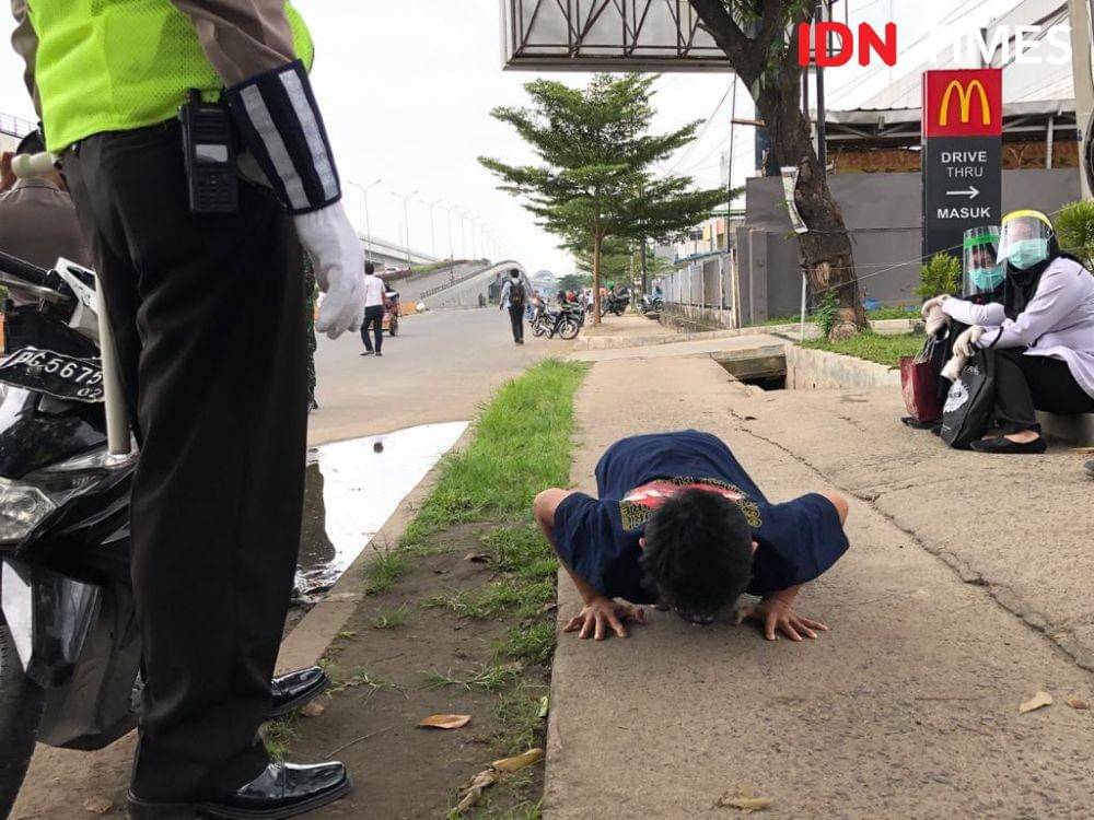 Pelanggar undang-undang berkendara tanpa menggunakan helm (IDN Times/Rangga Erfizal)