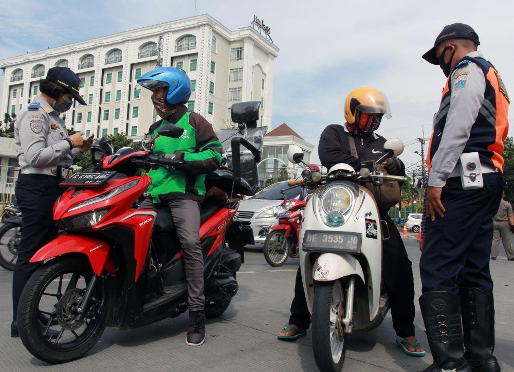Petugas Dishub Jakarta memeriksa surat kelengkapan kendaraan dan juga Surat Izin Keluar Masuk (SIKM) Jakarta saat razia plat nomor kendaraan luar Jakarta di Jalan Ciledug Raya, Jakarta, Rabu (27/5/2020). Pengendara yang tidak memiliki SIKM Jakarta kemudian diputar balik agar tidak memasuki wilayah ibu kota (ANTARA FOTO/Muhammad Iqbal)