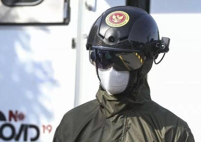 Petugas menggunakan helm pendeteksi suhu tubuh saat rapid test massal di Depok, Jawa Barat, Jumat (22/5/2020). Badan Intelijen Negara (BIN) menggunakan alat canggih berupa helm thermal KC wearable sebagai alat mengukur suhu tubuh (ANTARA FOTO/Asprilla Dwi Adha)