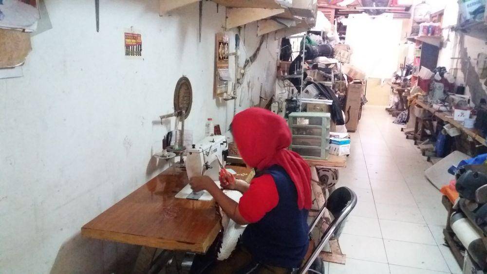 Salah satu karyawan disabilitas di Tiara Handicraft sedang menyelesaikan pengerjaan keset (IDN Times/Faz Nashrillah)
