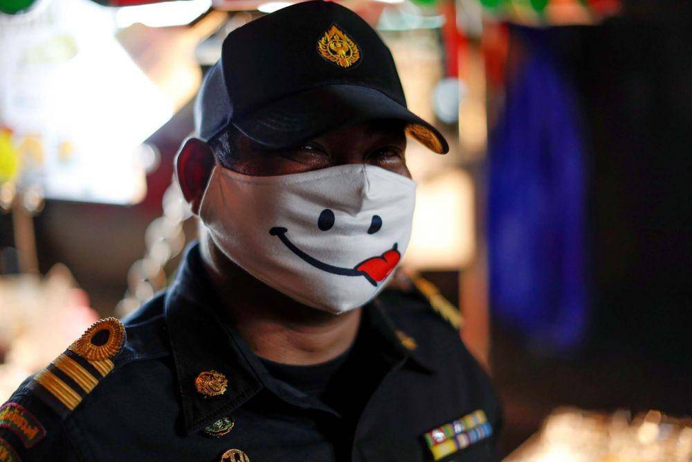 Seorang polisi memakai masker pelindung bergambar saat pandemik COVID-19 di Bangkok, Thailand, pada 3 Mei 2020. ANTARA FOTO/REUTERS/Jorge Silva